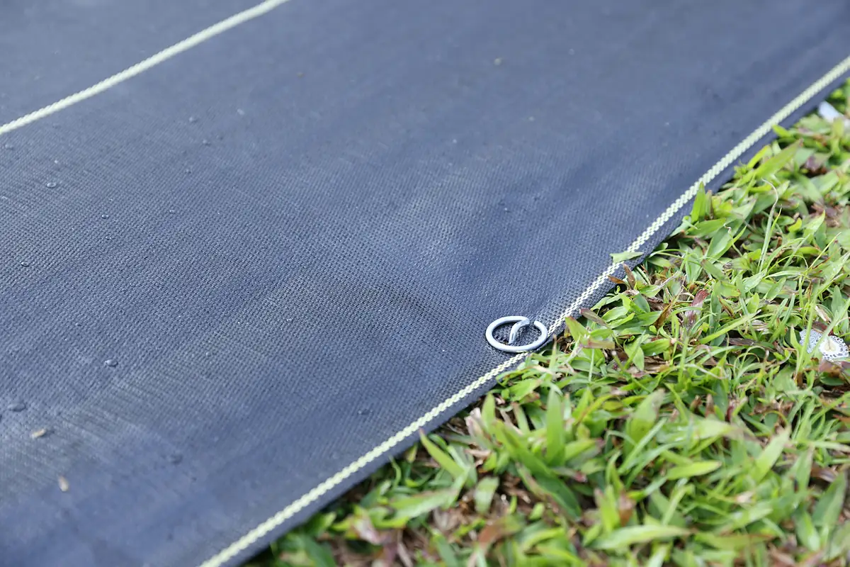 Close-up of SHIELD edge pinned over grass before mulch goes on