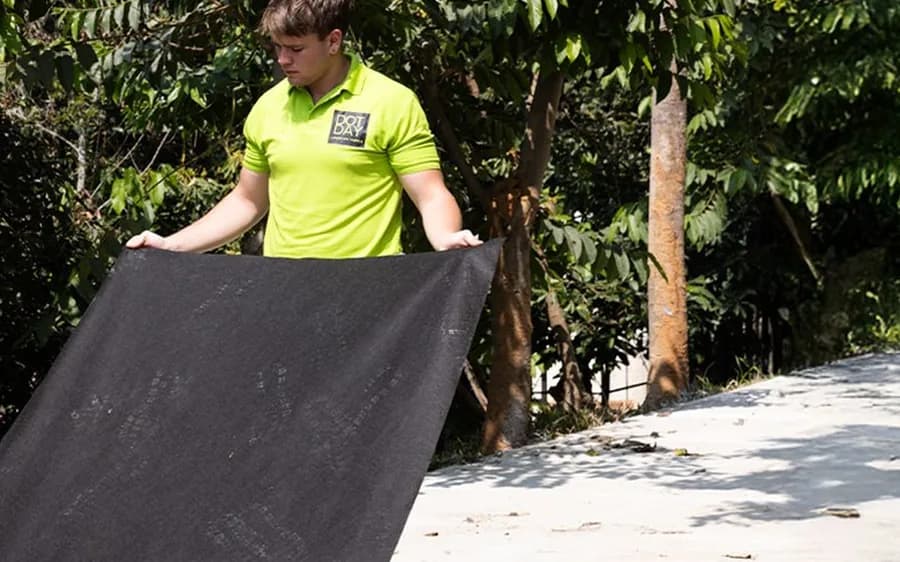 DOTDAY worker unrolling TERRA non-woven geotextile for soil separation