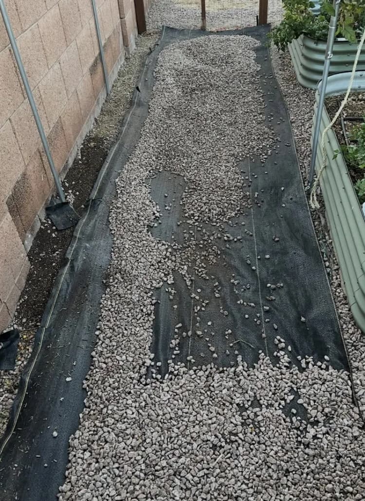 DOTDAY XBAR fabric laid under gravel along a side-yard path
