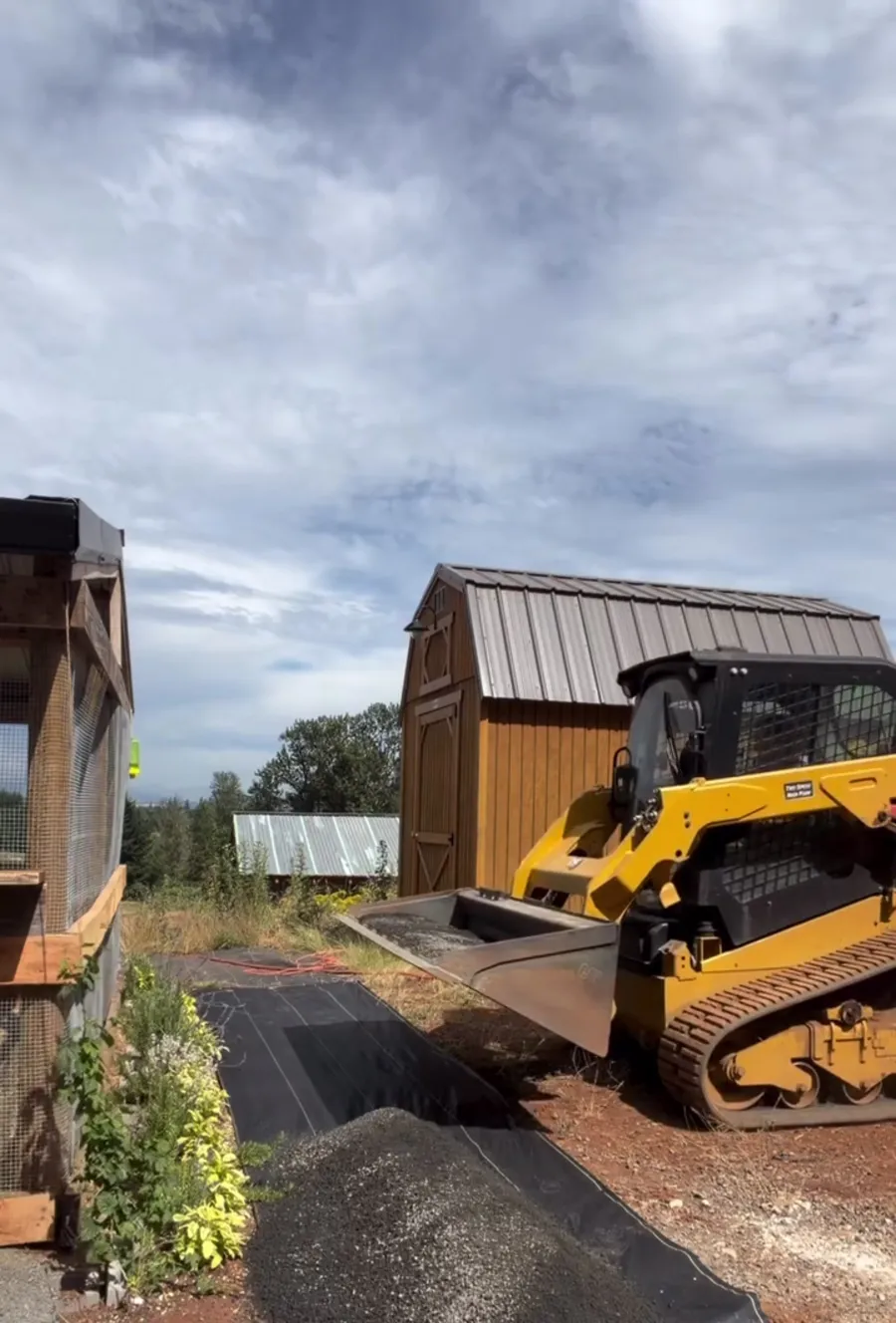 Skid steer dropping quarter minus gravel onto the fabric