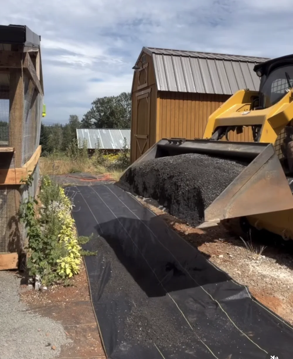 The coop run with fabric laid and rock staged