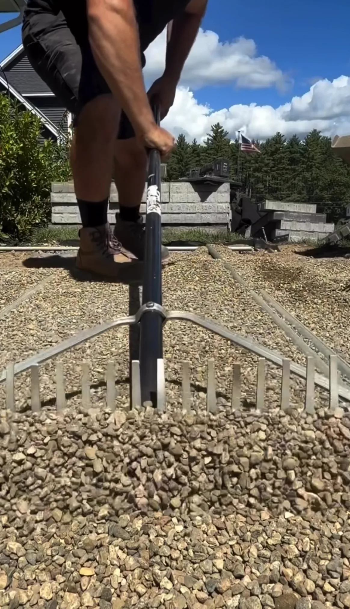 Raking the crushed stone base level over the geotextile