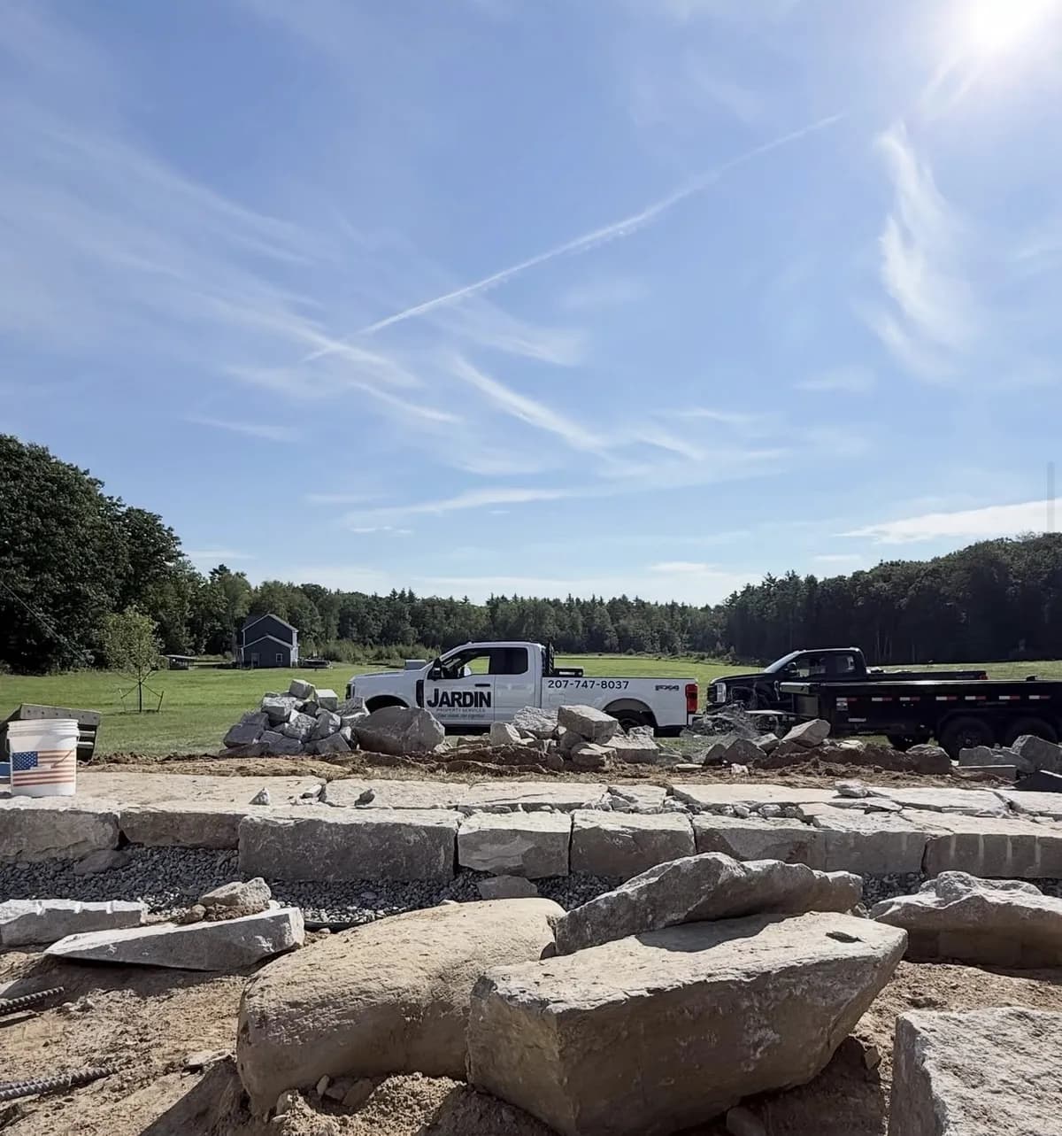 First course of stone blocks set on a crushed stone base during a retaining wall build