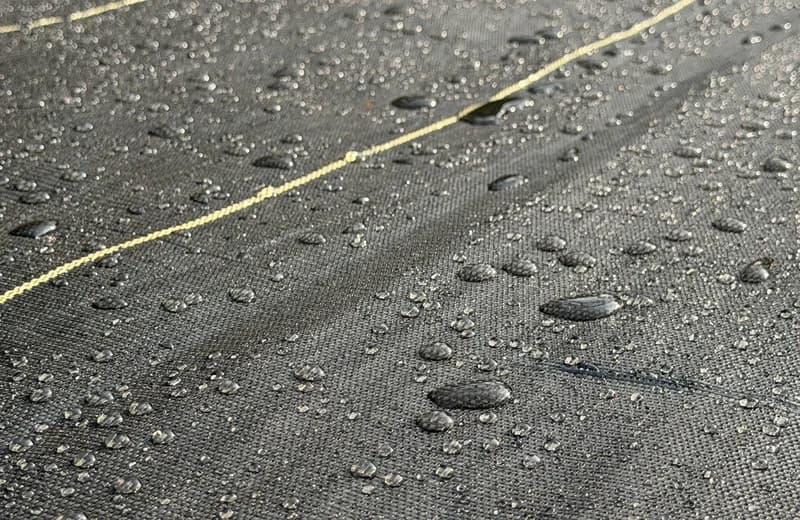 Drip irrigation lines running over DOTDAY SHIELD weed fabric on garden rows