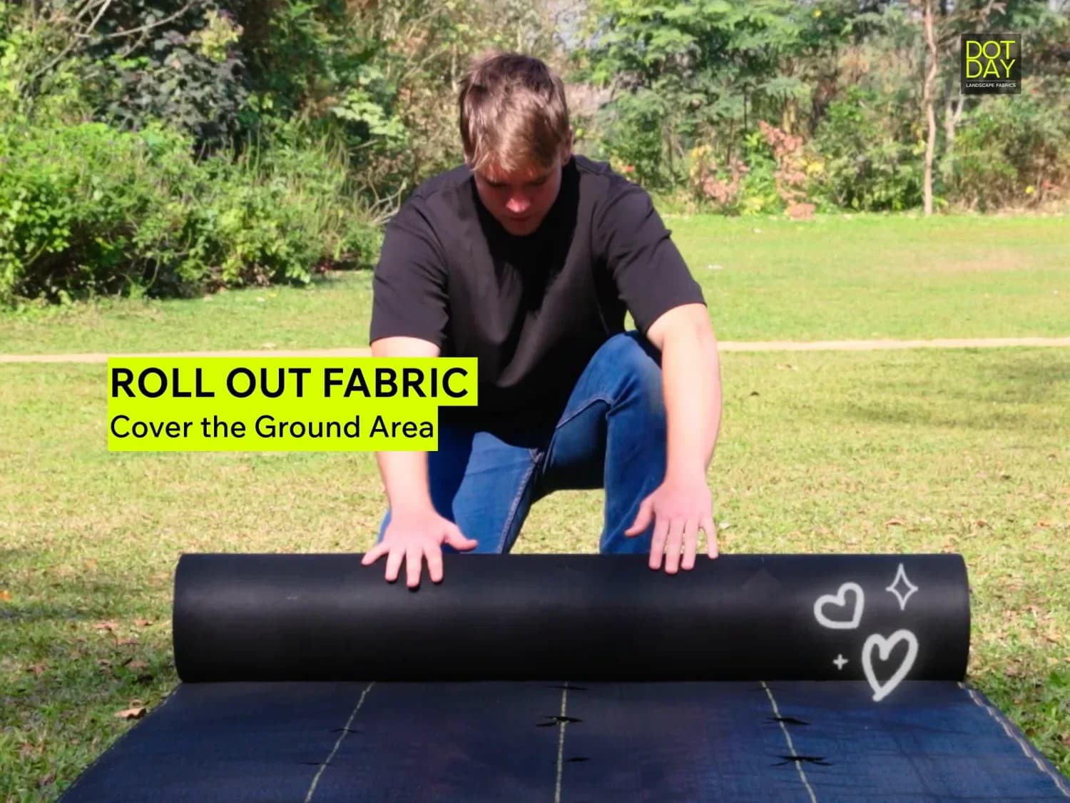 Installing DOTDAY SHIELD weed barrier fabric, rolling the woven cover across a garden bed