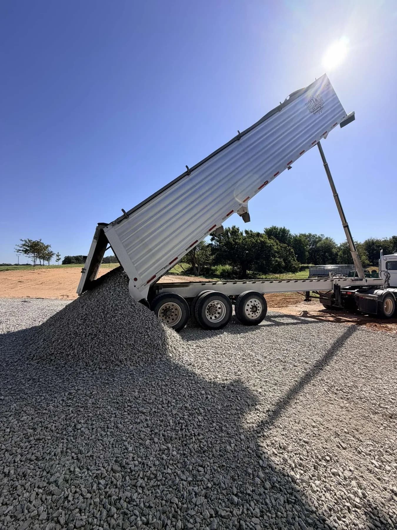 End dump tipping rock onto fabric for a gravel driveway