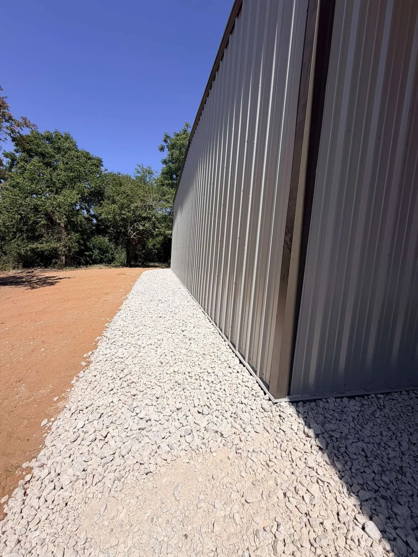 White rock spread and compacted along the shop wall over XBAR fabric